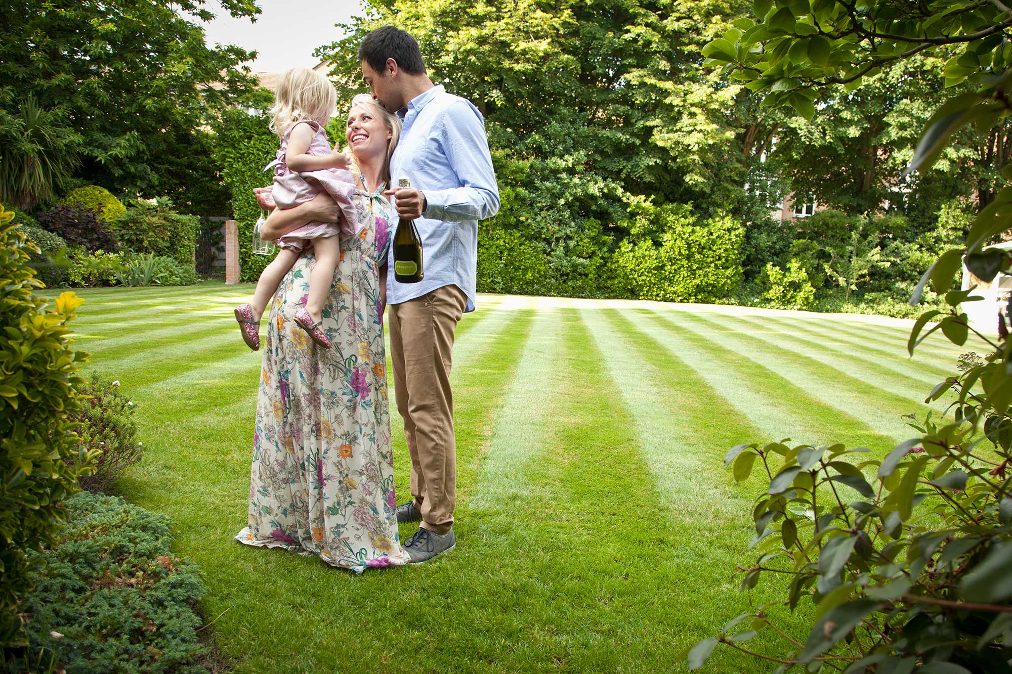 A happy family is enjoying the sunny day in their garden